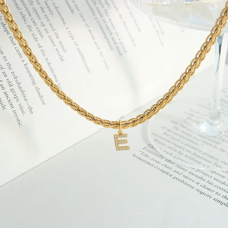 Collar con colgante de letra de circonita con incrustaciones de latón