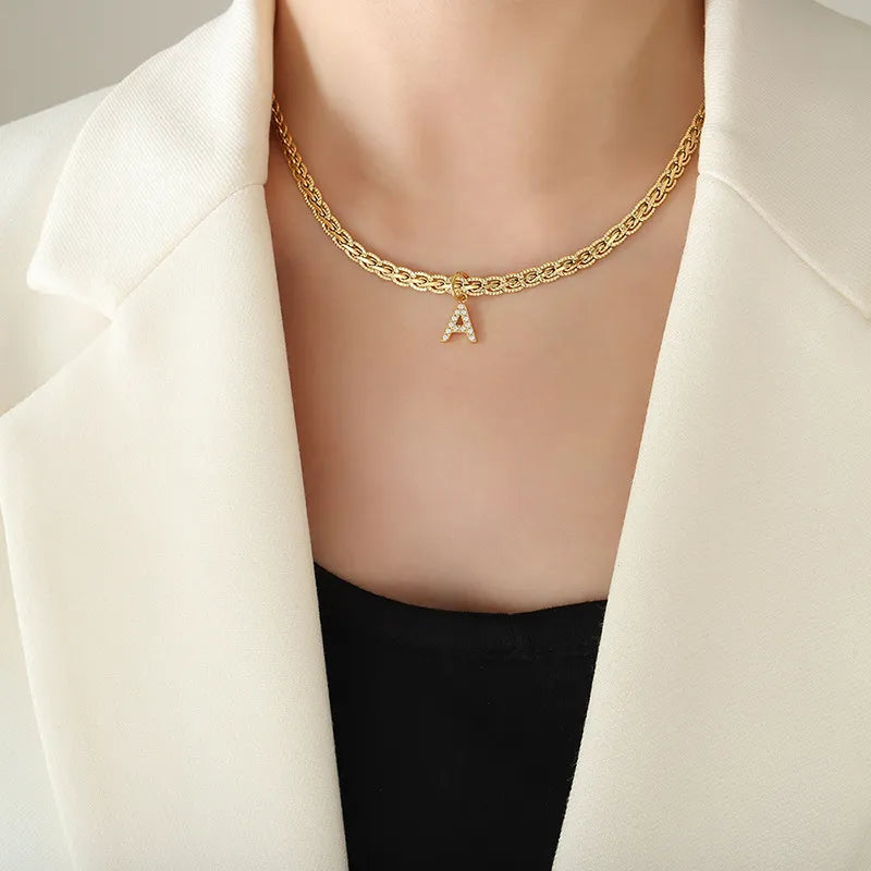 Collar con colgante de letra de circonita con incrustaciones de latón