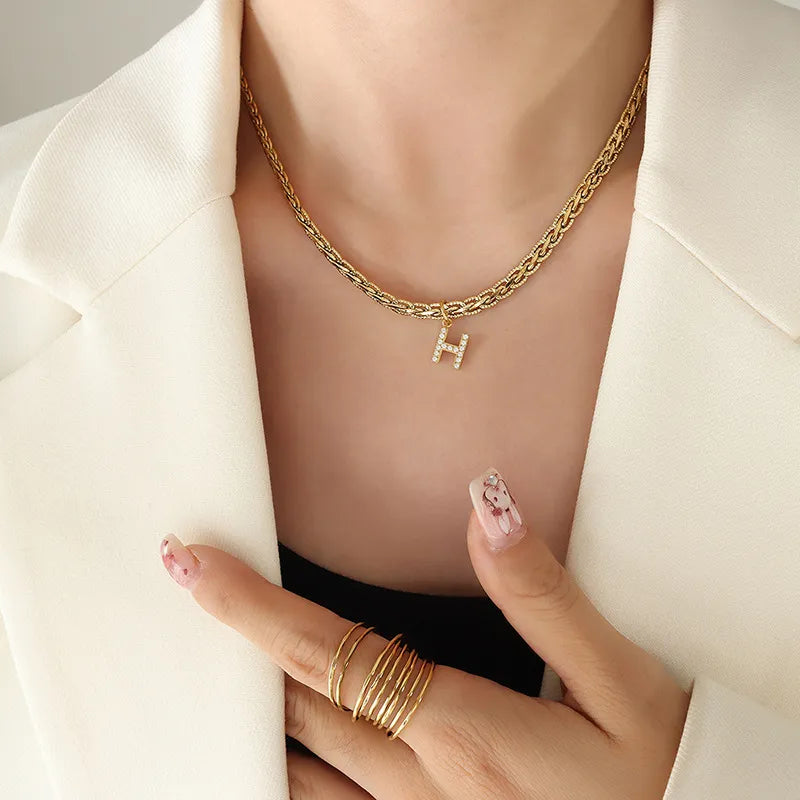 Collar con colgante de letra de circonita con incrustaciones de latón