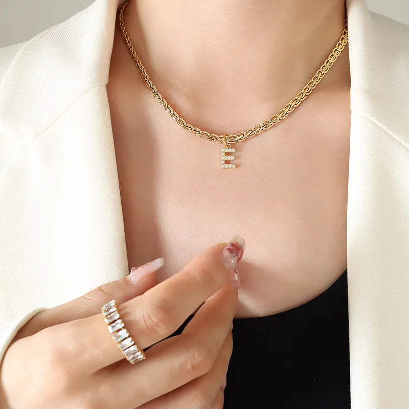 Collar con colgante de letra de circonita con incrustaciones de latón