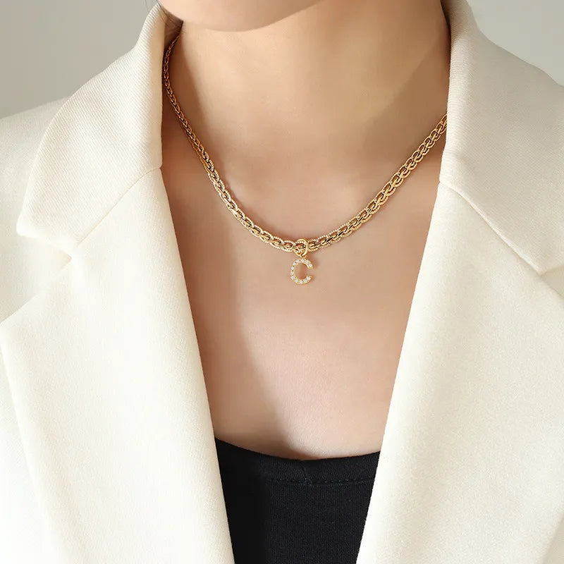 Collar con colgante de letra de circonita con incrustaciones de latón