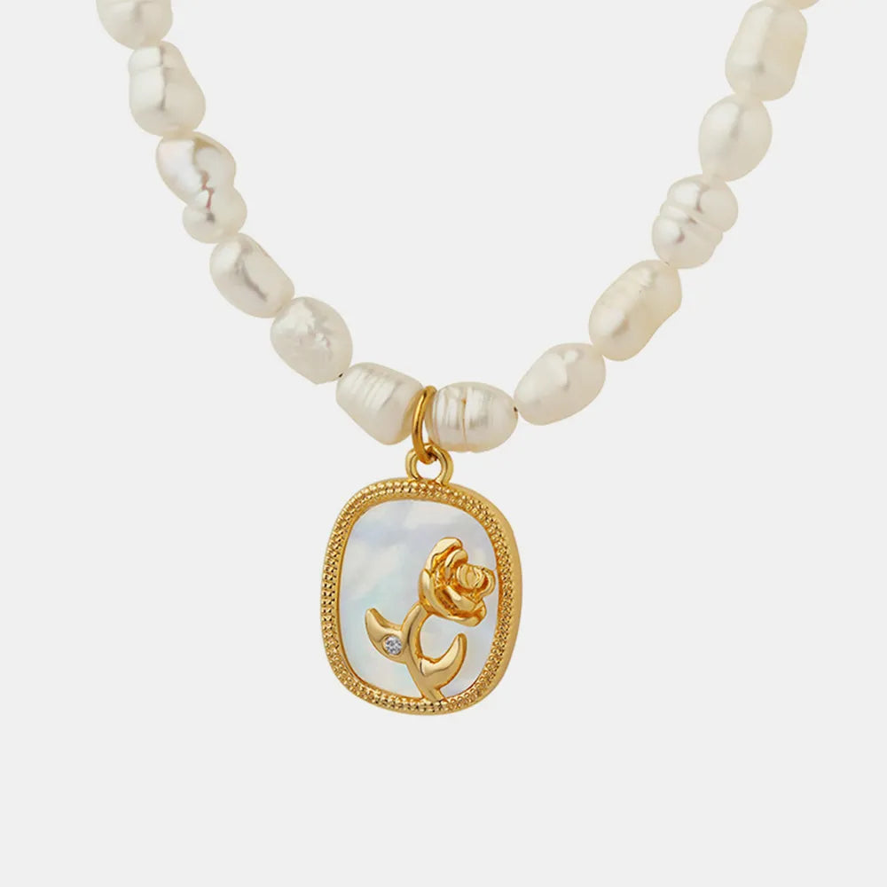 Collar con cadena de perlas de agua dulce barrocas francesas, placa ovalada con incrustaciones de circonitas de colores y flor en relieve.