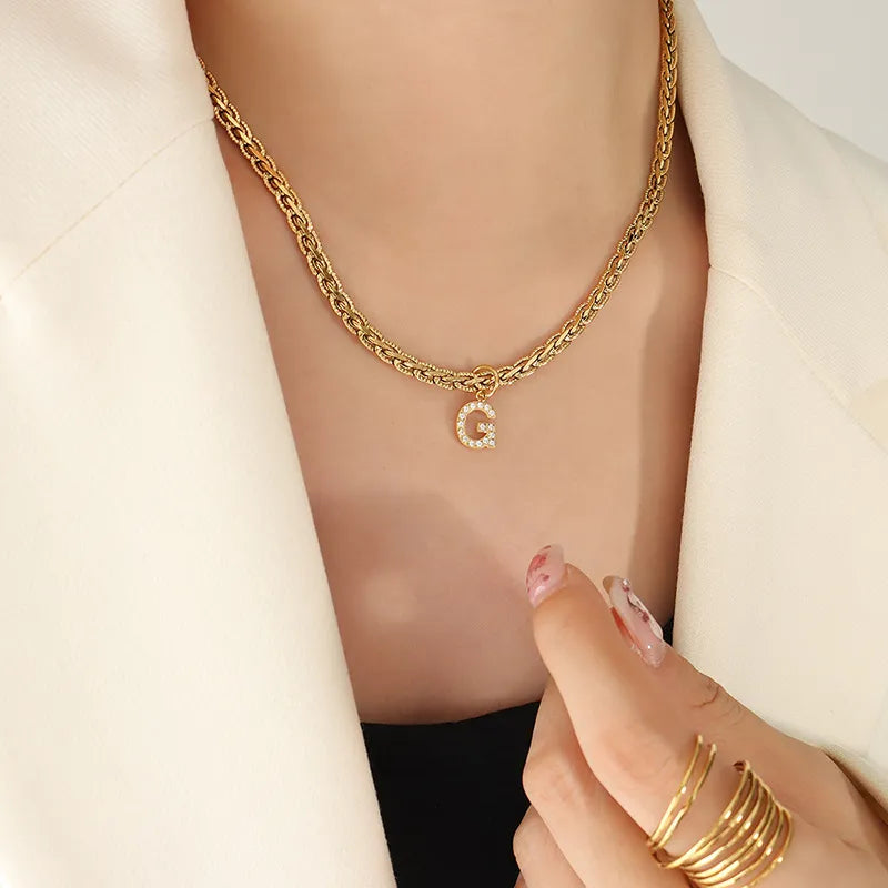 Collar con colgante de letra de circonita con incrustaciones de latón
