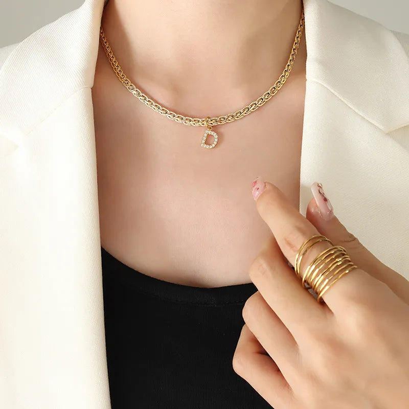 Collar con colgante de letra de circonita con incrustaciones de latón